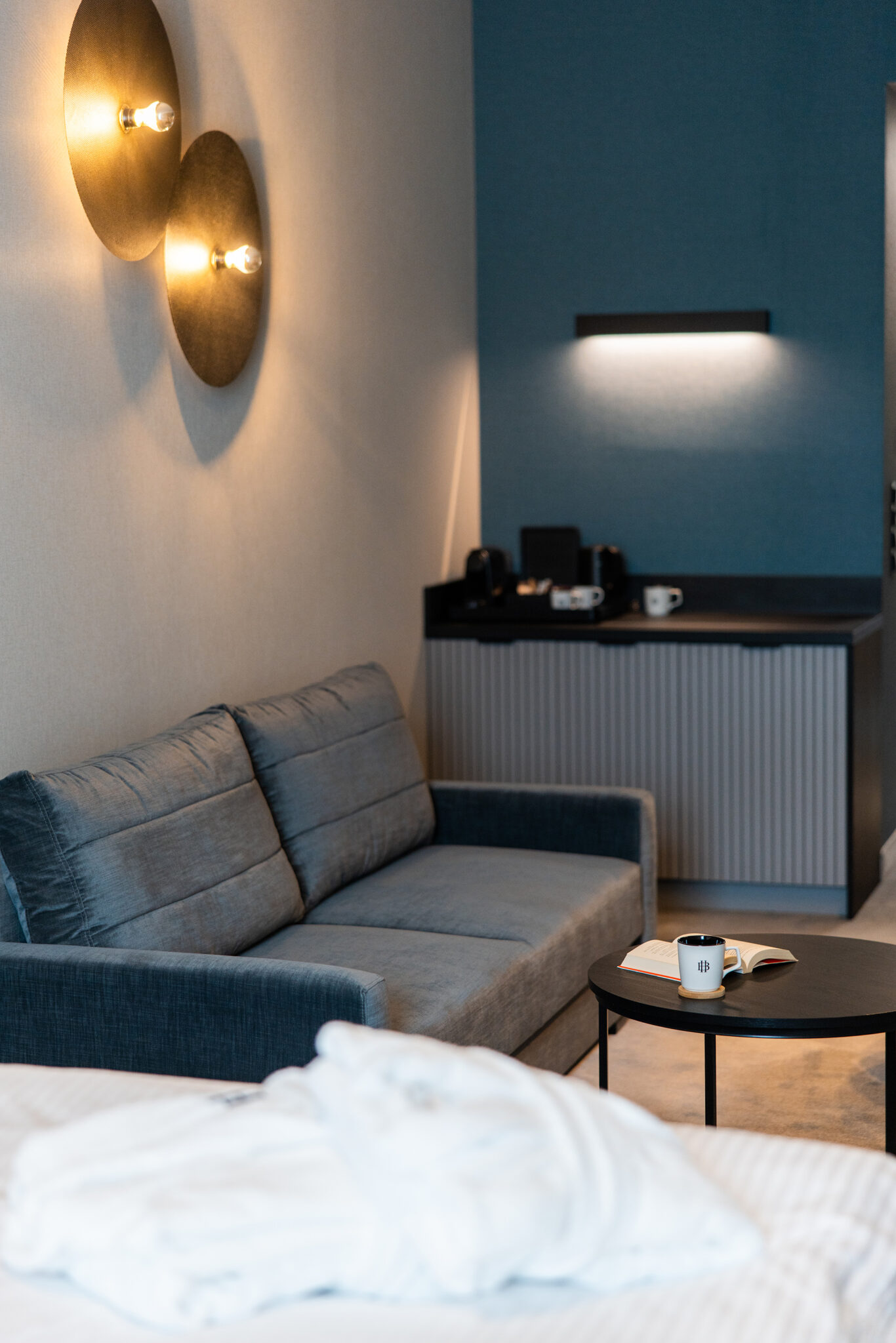 Szara sofa, stolik kawowy i komoda w nowoczesnym wnętrzu apartamentu